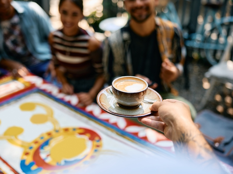 close-up-of-waiter-serving-coffee-in-a-cafe