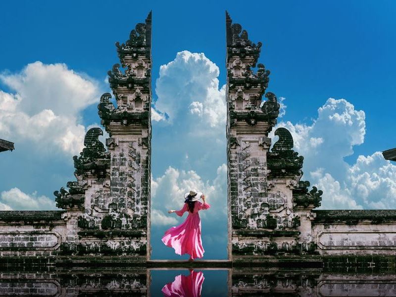 female-with-a-pink-dress-standing-at-temple-gates