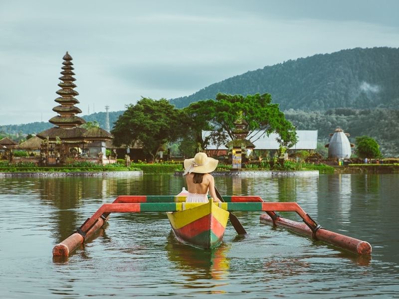 young-woman-traveler-paddling-on-a-wooden-boat