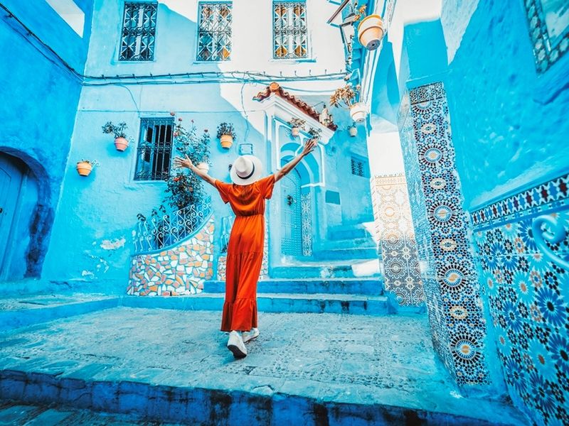 young-woman-with-red-dress-visiting-the-blue-city