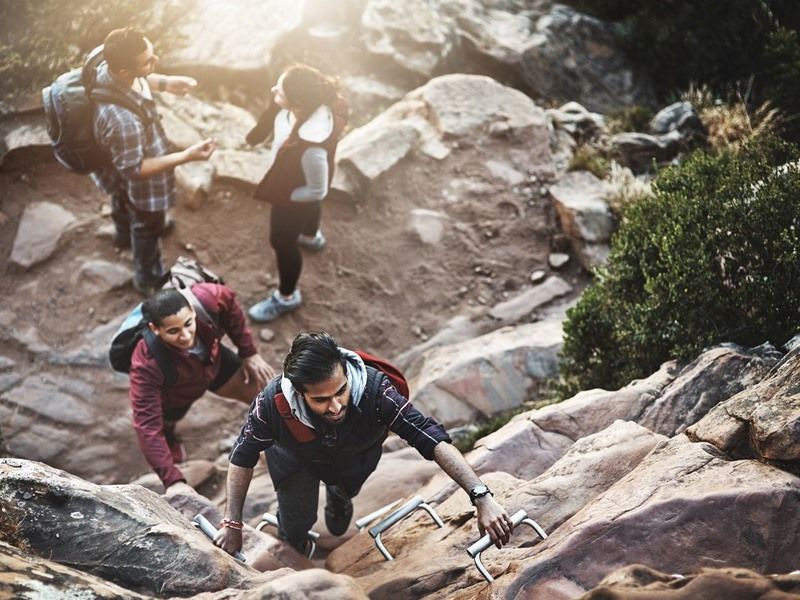 shot-of-a-group-of-friends-climbing-a-ladder