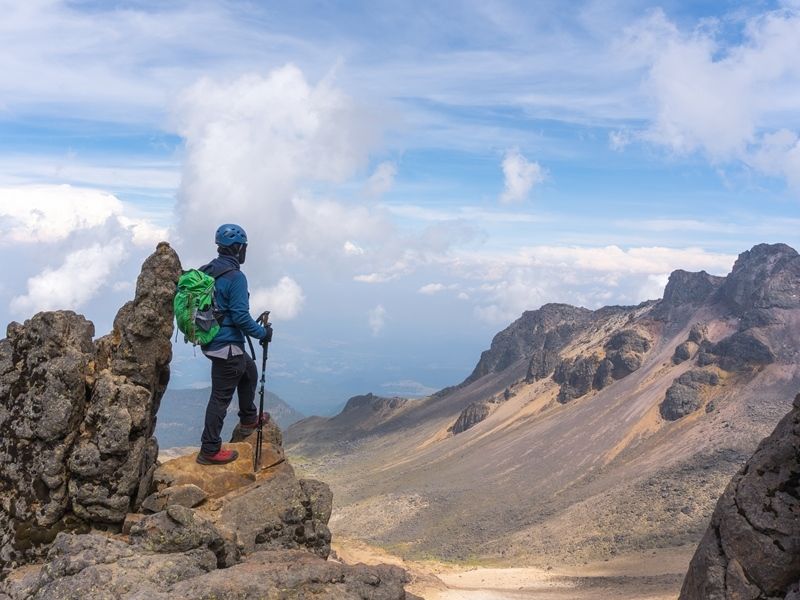 back-view-of-a-hiker-with-a-green-backpack-on-top