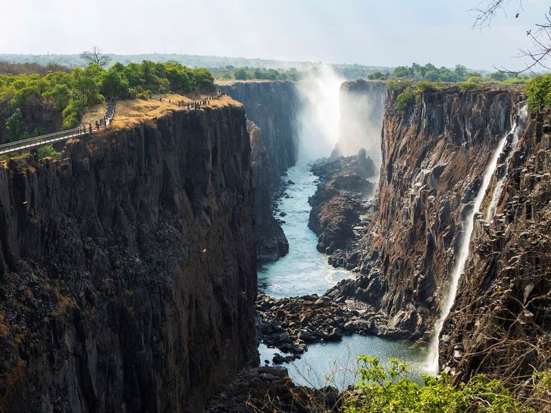 Victoria Falls viewed from the Zambian side, deep gorge with vertical sides, waterfall with torrents of white water.